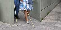 A blind person with a white stick. Photo
